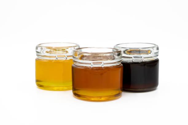 istock Jars with three different types of honey isolated on a white background 1494057160