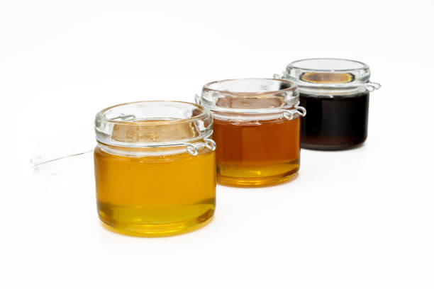 istock Jars with three different types of honey isolated on a white background 1494057161