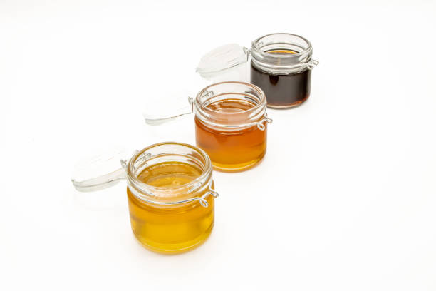 istock Jars with three different types of honey isolated on a white background 1494057162