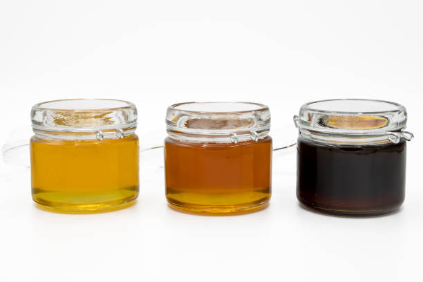istock Jars with three different types of honey isolated on a white background 1494057165
