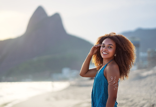 portrait young black afro woman on the beach with mountain in the background in Ipanema Brazil