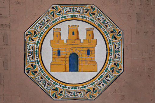 Seville, Spain - Apr 5, 2019: Tiles with Castile Coat of Arms at Plaza de Espana - Seville, Andalusia, Spain