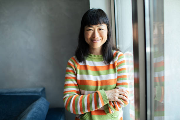 istock Young Japanese woman smiling while sitting on a couch and looking at the camera 1494063550