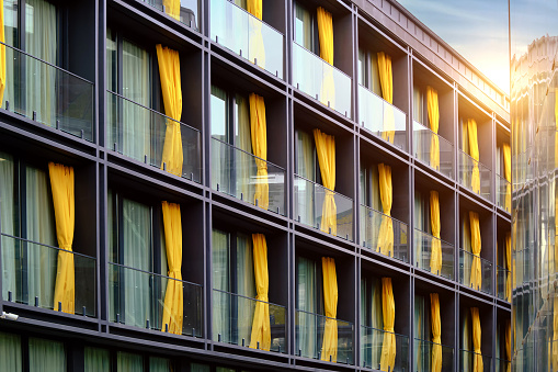 Beautiful exterior of a modern hotel with decorative yellow curtains in the historic part of the city.