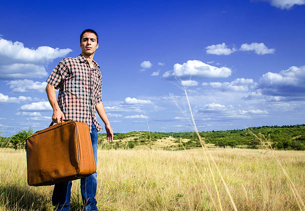 Spring and Terricons. A man with a beard in a cap and a leather jacket\nIt goes through green grass against artificial mountains and rivers