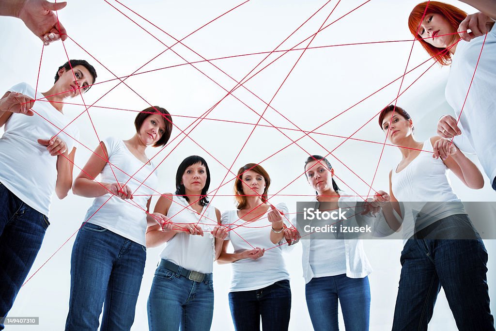 Tangled in the network Network concept. Group of women holding red rope. Internet Stock Photo