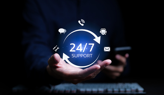 A man holding icon virtual 24/7 support services for worldwide nonstop and full-time available contact of service concept. Assistance customer services, Care and consulting client 24hr, Call Center,
