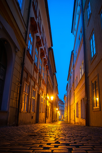Romantic narrow street lit by orange street lamps. Lesser town, Prague.