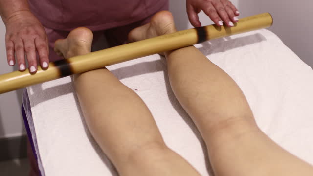 Lymphatic drainage leg massage with a bamboo stick at spa salon