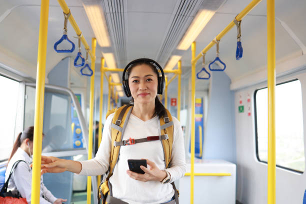 istock Woman passenger backpacker  using phone in subway car,Asian oman passenger with casual suit using the technology tablet in the Skytrain rails or subway for travel in the big city, lifestyle and transportation concept 1494076320