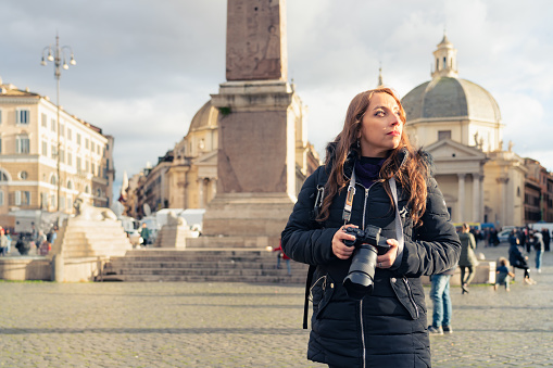 Portrait of smiling young Latin woman tourist in Piazza del Popolo in Rome, Italy