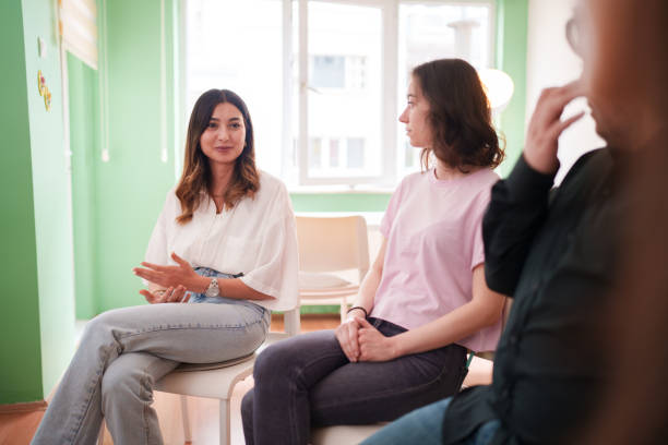 istock Young woman talking in group therapy 1494082081
