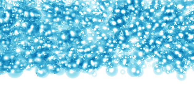 Colourful water beads balls on a circle drinking glass on a white background