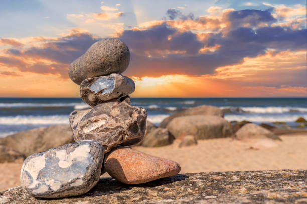piramidi di pietra e sfera di vetro sulla spiaggia di sabbia da sogno del mar baltico a rügen fino allo spettacolare tramonto arancione - perfection nature balance stone foto e immagini stock