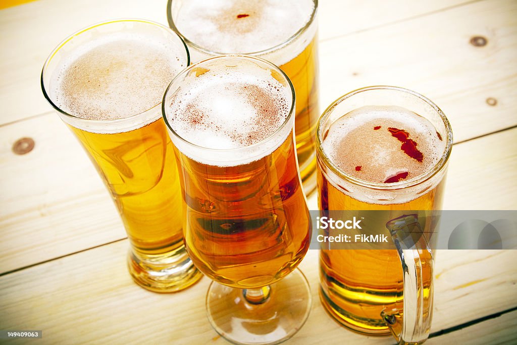 Beer mugs Four pints of cold beer on a wooden table. The picture was taken in horizontal orientation dSLR Beer - Alcohol Stock Photo