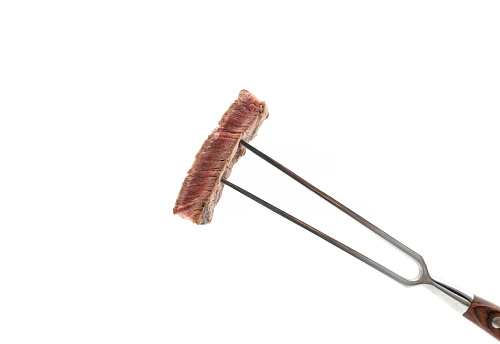 Rare beef on a fork isolated on whute.