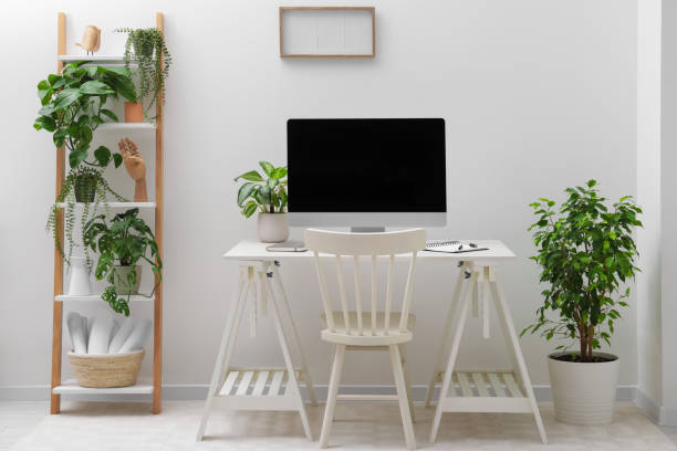 istock Spacious workspace with desk, chair, computer and potted plants at home 1494093022