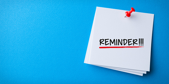 White Sticky Note With Reminder And Red Push Pin On Blue Background