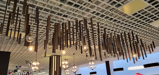 Hanging lamps adorn the ceiling. The interior of the room is decorated with ceiling lights.