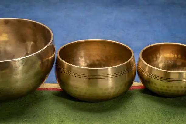 handmade Tibetan singing bowls against abstract paper landscape, sound therapy for healing, relaxation and meditation