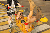 Two young blonde girls have fun with shopping cart. Fashion woman