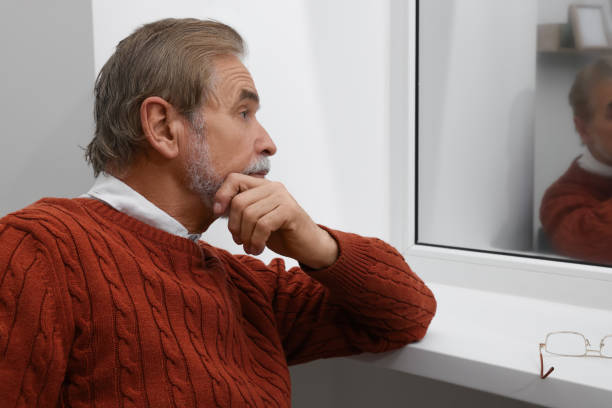 istock Upset senior man looking at window indoors. Loneliness concept 1494108015