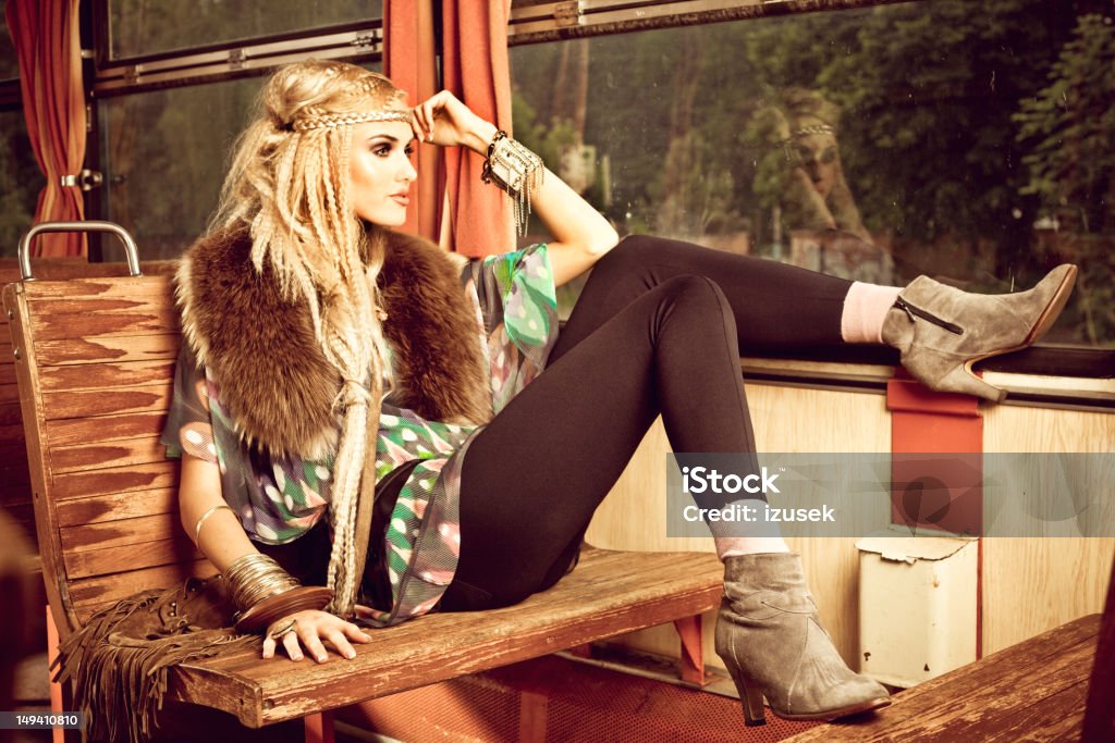 Beautiful hippie in vintage train A beautiful young adult woman wearing in hippie style sitting in a vintage train and looking out the window. Fashion Stock Photo