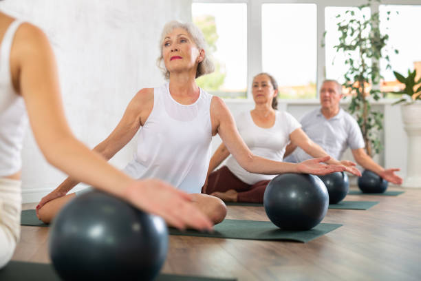 istock Group of elderly people doing pilates with soft ball in studio 1494112755