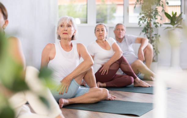 istock Group of elderly people doing yoga on mat in studio 1494113057