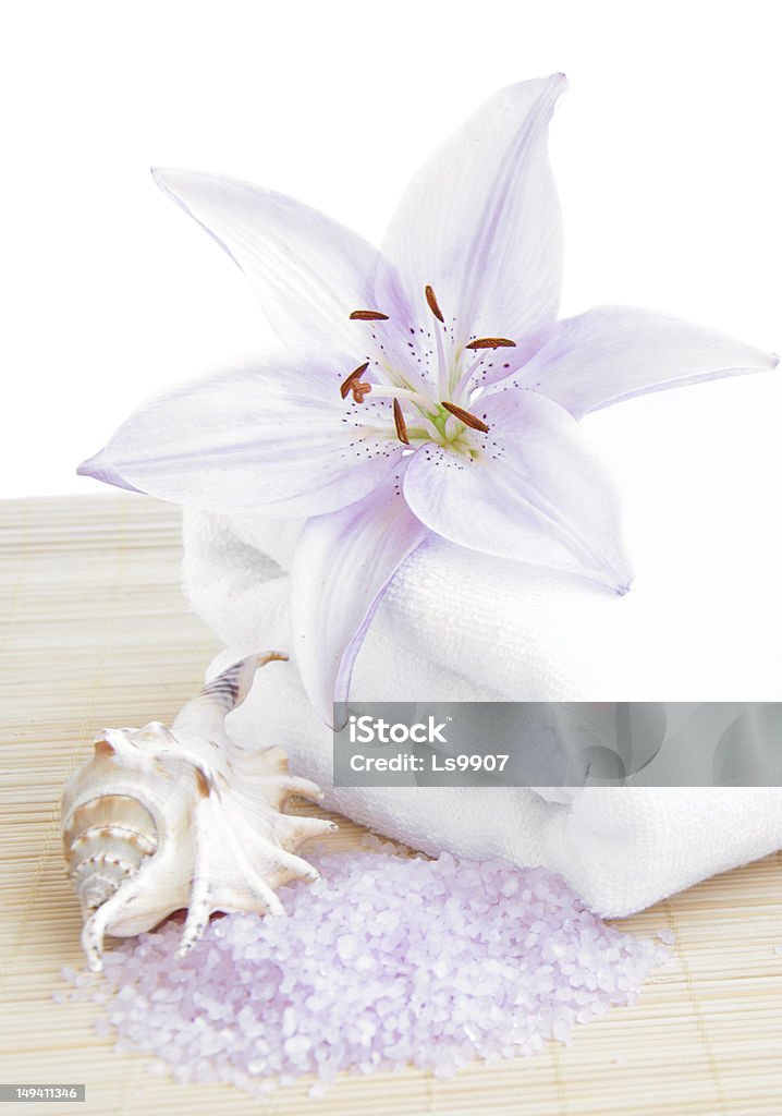 Spa Towel with flower Spa Towel with pink lily and sea salt on a bamboo rug Animal Shell Stock Photo