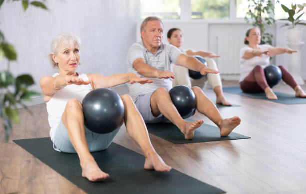 istock Elderly woman doing pilates with soft ball in studio 1494114385