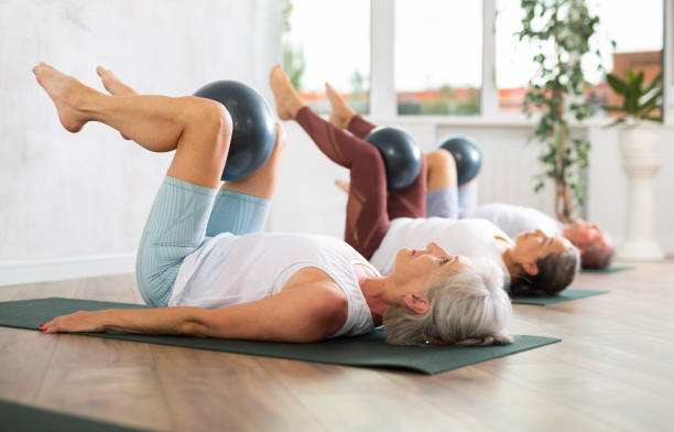 istock Group of elderly people doing pilates with soft ball in studio 1494115752