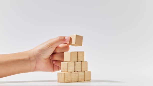istock Hand putting wood cube arranges in a pyramid shape, business concept mock-up. 1494124657