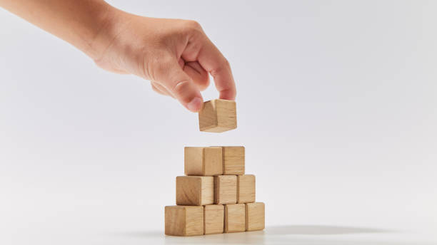 istock Hand putting wood cube arranges in a pyramid shape, business concept mock-up. 1494124665