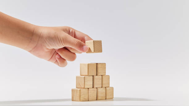 istock Hand putting wood cube arranges in a pyramid shape, business concept mock-up. 1494125735