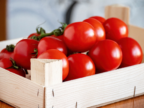 Freshly harvested ipe vine-ripened red tomatoes in a wooden crate