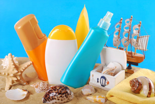summer skin care and sun protection cosmetics arranged on the beach