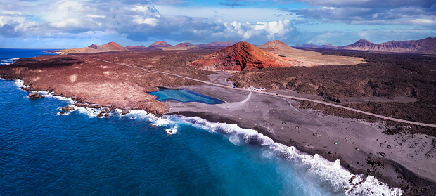 Volcanic Lanzarote island scenery. aerial  panoramic drone view  of Los Hervideros caves and cliffs and Red mountain . popular tourist destination Canary islands