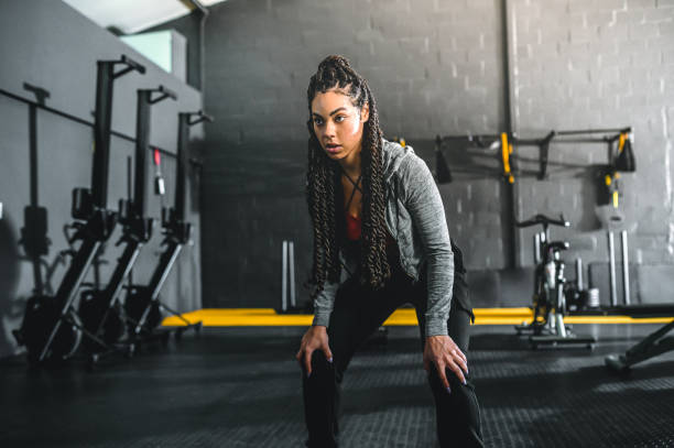 istock Focused young woman holding half squat in gym 1494134838