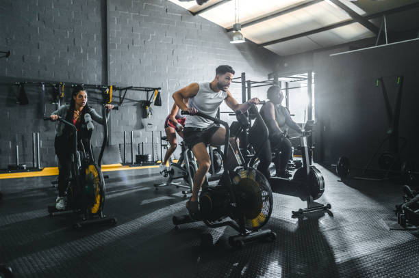 istock Athletes exercising on bicycles in gym 1494134872