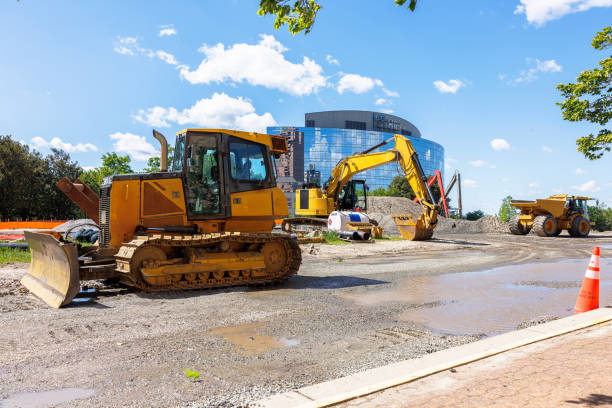 Road widening and road scraper working in financial district. Excavator digging and destructing ground for new building complex in Newport News, VA stock photo