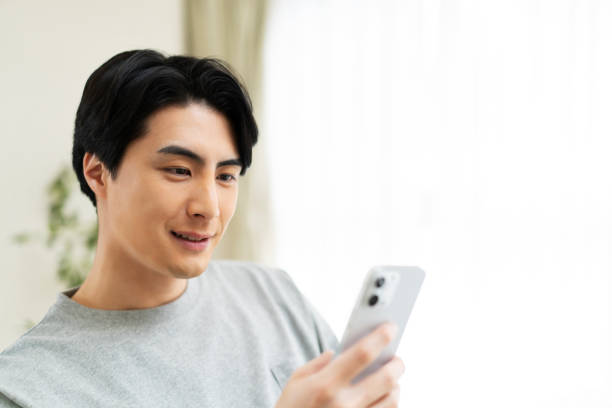 istock Japanese man using mobile phone at home 1494140011