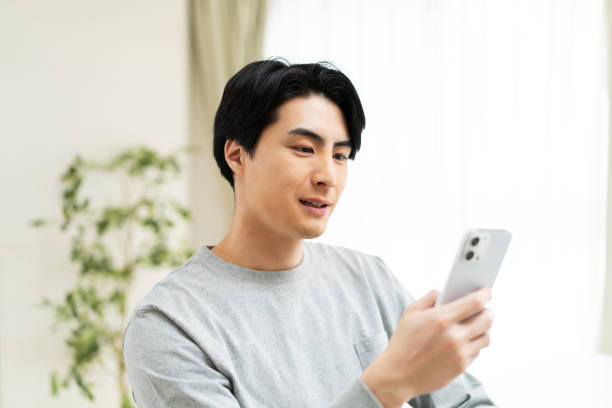 istock Japanese man using mobile phone at home 1494140022