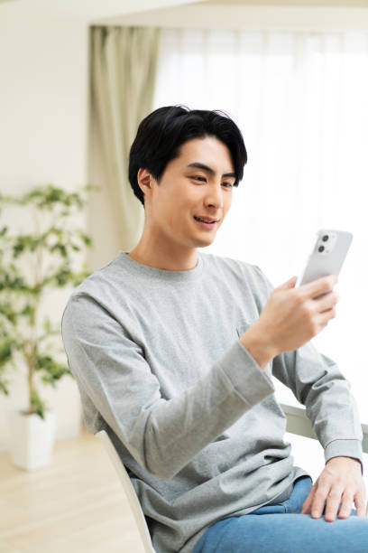 istock Japanese man using mobile phone at home 1494140027