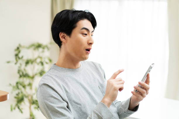 Japanese man using mobile phone at home