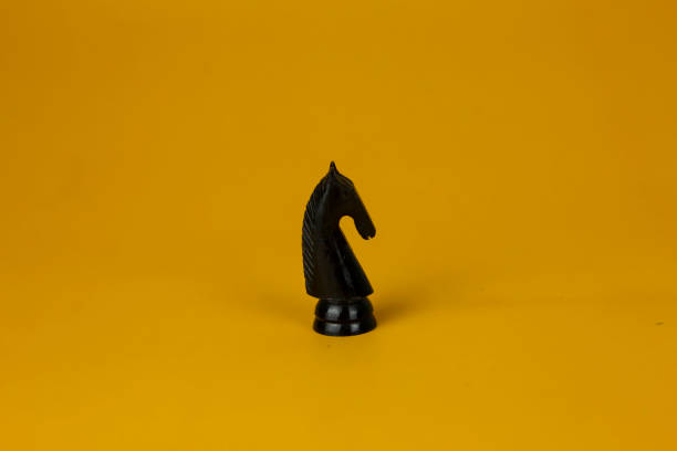 istock A black horse Chess standing for facing to problem on business on  isolated yellow background, used for success and stategy concept 1494141267