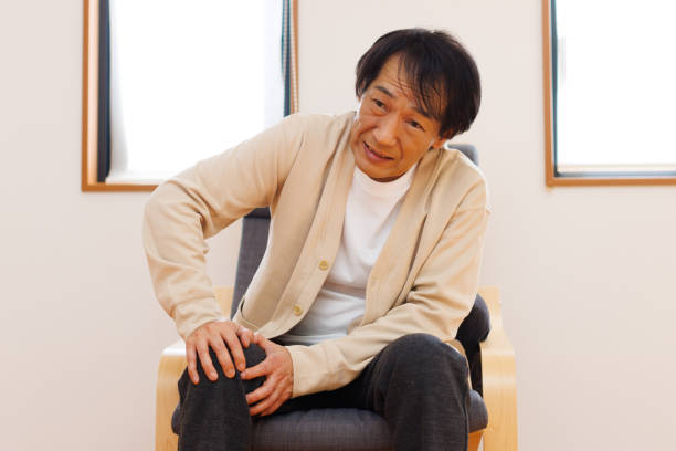 Hombre japonés maduro que sufre de dolor de rodilla - foto de stock