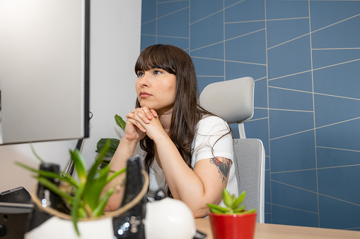 Medium shot of a young woman working in her home office and attending a meeting with copy space.