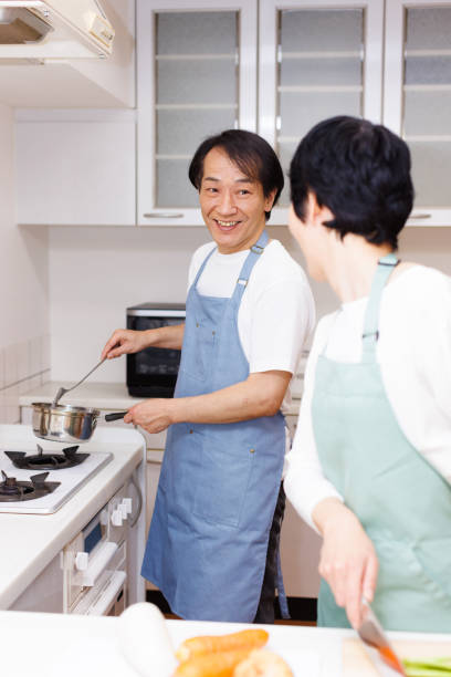 Mature Japanese couple cooking at the kitchen
