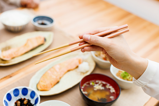 Woman holding chopsticks with meal